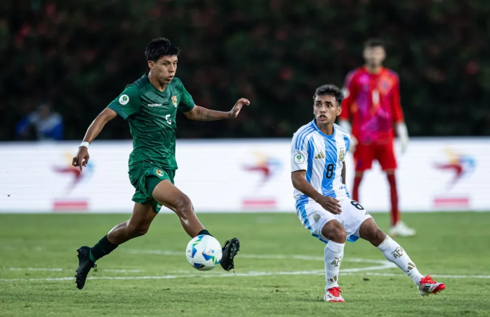 Jhonny Cuiza, jugador de la selección boliviana, se anticipa al argentino Milton Delgado. Foto: Conmebol
