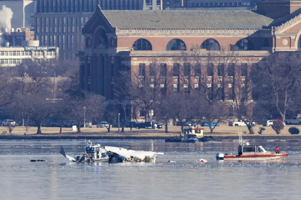 Equipos de rescate buscan entre los restos de un avión comercial que colisionó con un helicóptero militar. Foto: EFE