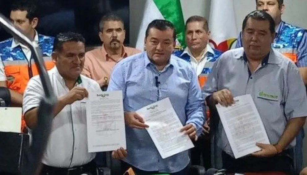 El alcalde de la ciudad de Santa Cruz, Jhonny Fernández, y los dirigentes de los transportistas, muestran el decreto que fija la nueva tarifa. Foto: Red Uno