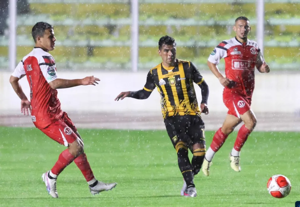 Leonel López (centro), jugador del Tigre, mete un pase en profundidad pese a la marca de Daniel Camacho. Foto: Agencia Marka Registrada