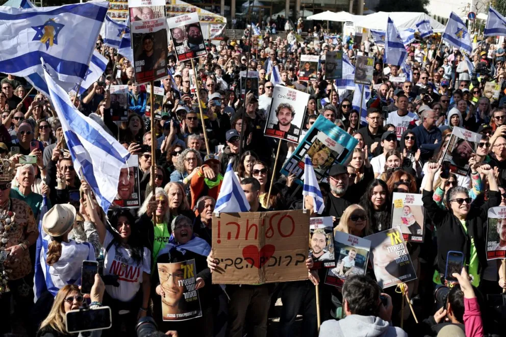 Numerosos israelíes miran la transmisión en vivo de la liberación de tres rehenes israelíes de Gaza, fuera de la base militar Kirya, en Tel Aviv, Foto: EFE
