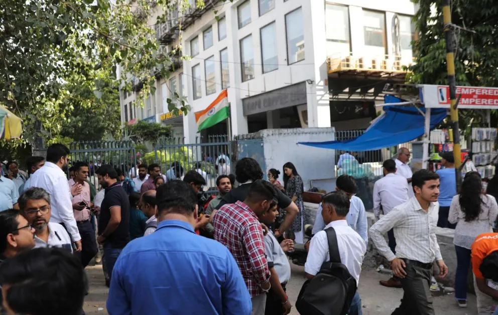 Personas afuera de sus oficinas después de un sismo en Nueva Delhi, en una imagen de archivo. Foto: EFE