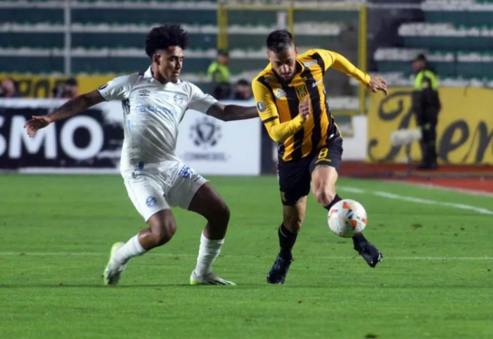 Luciano Ursino (der.) se escapa a la marca de un defensor del Gremio en el partido de abril de 2024. Foto: Alejandro Apaza