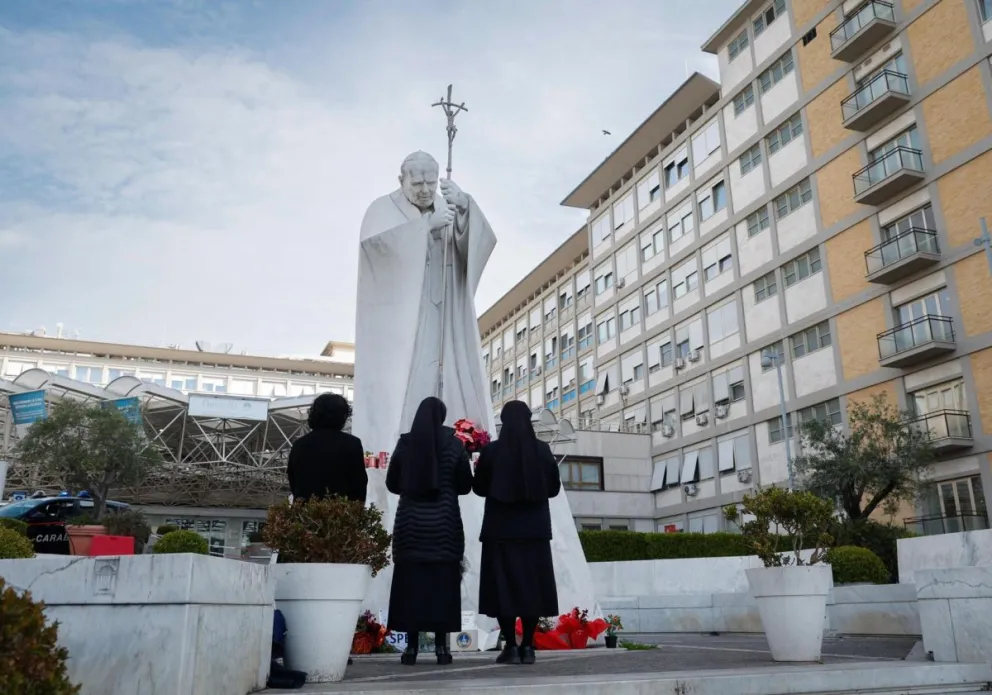 Monjas ante la estatua de Juan Pablo II en el hospital Gemelli. Foto: EFE