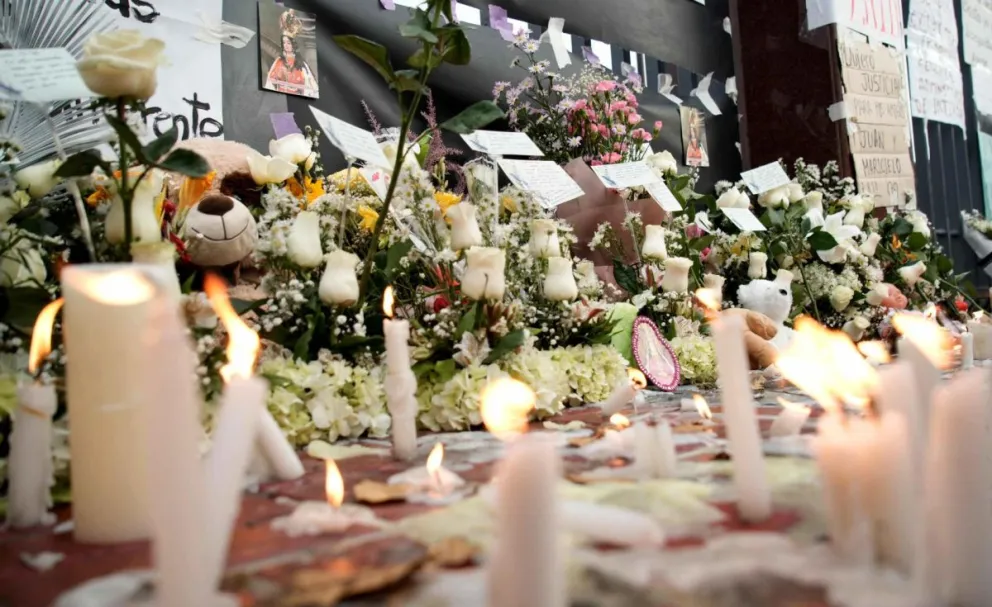 Foto de velas y flores durante una vigilia por las personas fallecidas tras el desplome de parte del techo del centro comercial Real Plaza, este domingo en Trujillo. Foto: EFE