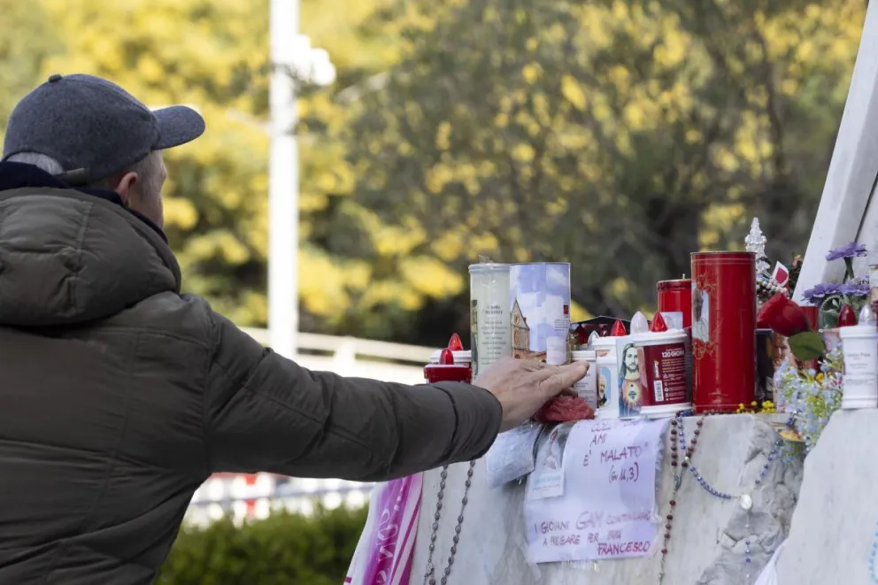 Fieles rezan frente a la estatua de Juan Pablo II en la entrada del Hospital Gemelli, donde está hospitalizado el Papa Francisco, en Roma. Foto: EFE