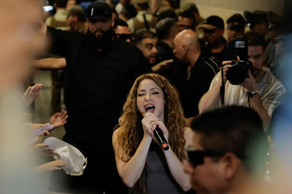 La cantante colombiana Shakira canta a sus seguidores frente al Hotel Mandarin, donde se alojaba tras la cancelación de sus dos conciertos en Chile. Foto:EFE
