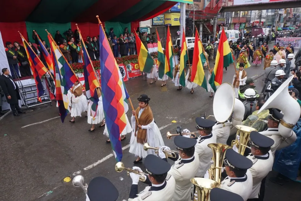 Mujeres de pollera con banderas en el desfile de este miércoles. Foto: APG 
