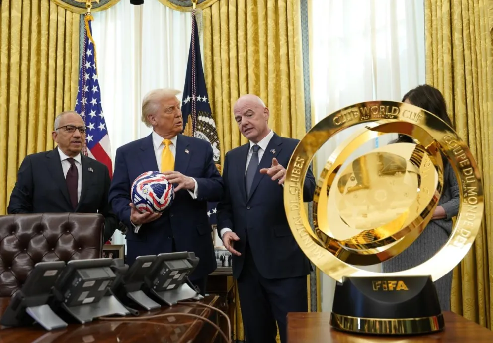 Gianni Infantino (der.), presidente de FIFA, y Donald Trump, presidente de Estados Unidos, y otras autoridades posan junto al trofeo del mundial de clubes. Foto: EFE