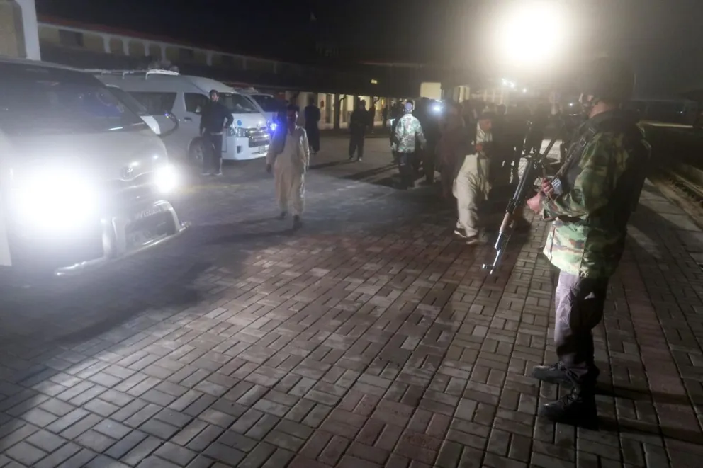 Los agentes de seguridad paquistaníes hacen guardia después de que los pasajeros rescatados del tren expreso. Foto: EFE