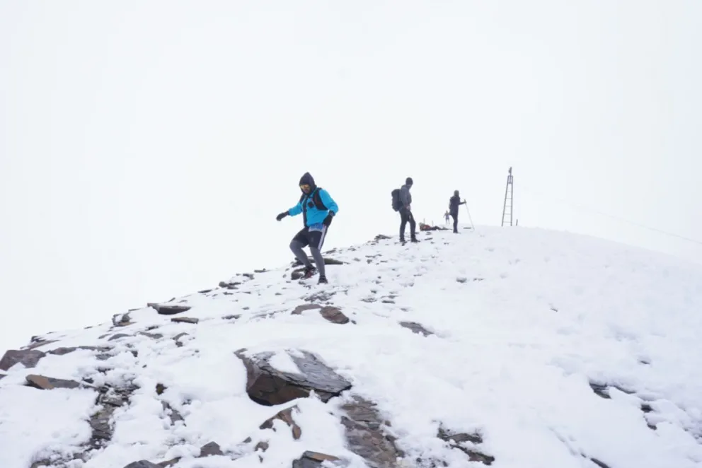 Tres participantes bajan por una colina llena de nieve en plena neblina. Foto: Skyrunning Bolivia.