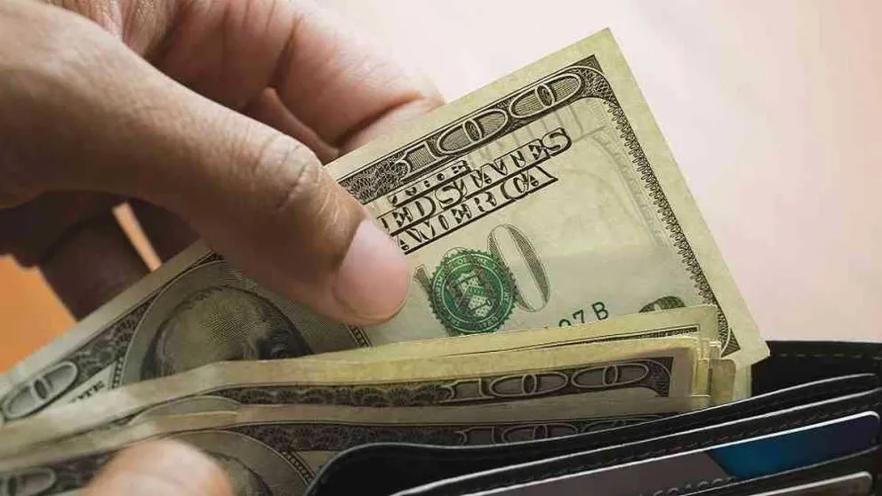 Una imagen referencial de una persona contando dólares. Foto: ABI 