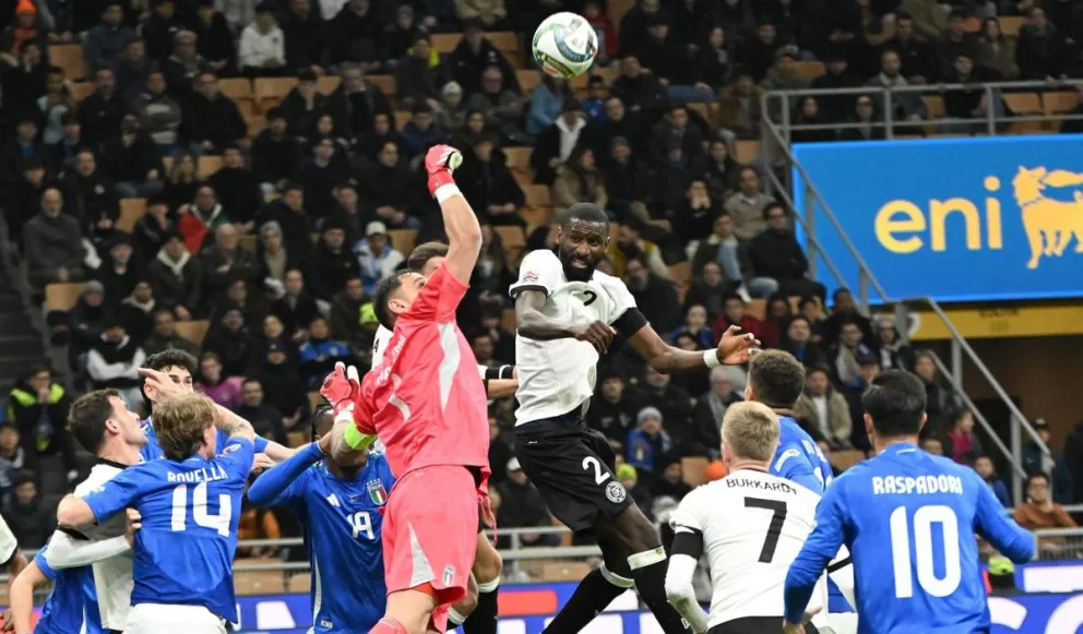 El alemán Rudiger (de blanco) salta de cabeza ante el arquero italiano Donnarumma. Foto: EFE.