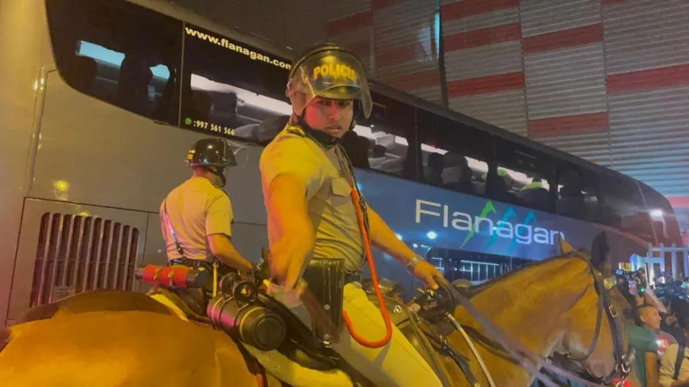 Efectivos de Policía montados en caballos escoltan al bus de la Verde a la llegada al estadio. Foto: Jorge Asturizaga.