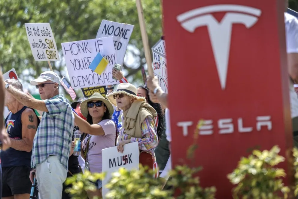Un grupo de persona fue registrado este 22 de marzo al protestar frente a un concesionario de la automotriz eléctrica estadounidense Tesla, en Fort Lauderdale (Florida, EEUU). Foto: EFE