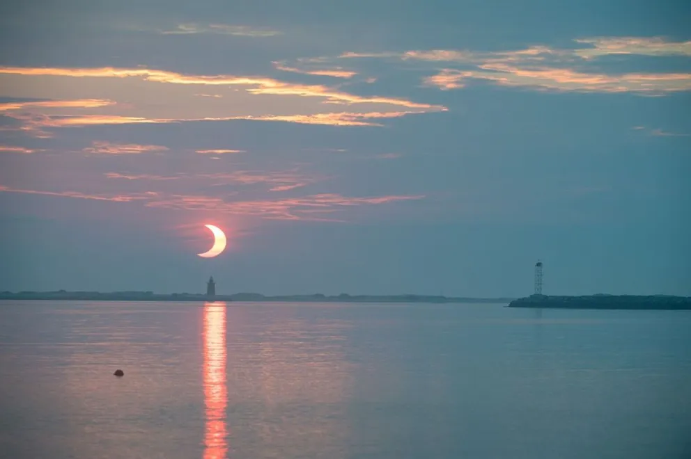 Un eclipse solar parcial mientras el Sol sale detrás del Faro del Rompeolas de Delaware, en Lewes Beach, Delaware. Foto: Nasa
