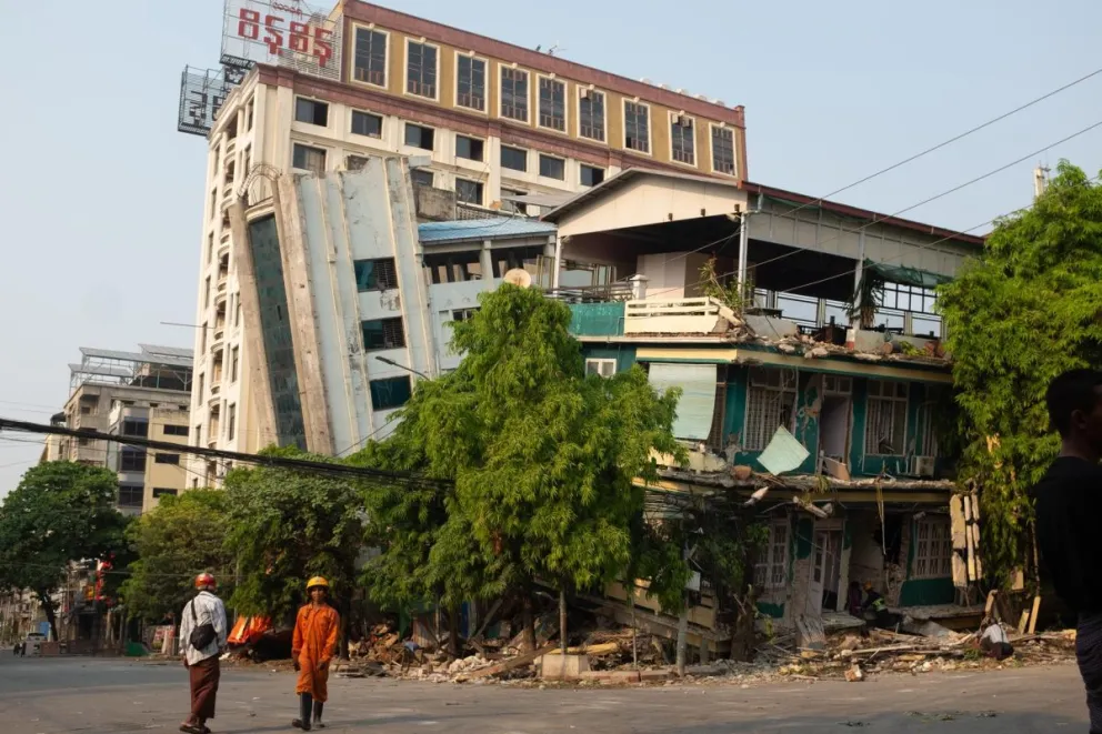 Rescatistas caminan este sábado frente a un edificio dañado tras un terremoto en Mandalay (Myanmar).  Foto: EFE