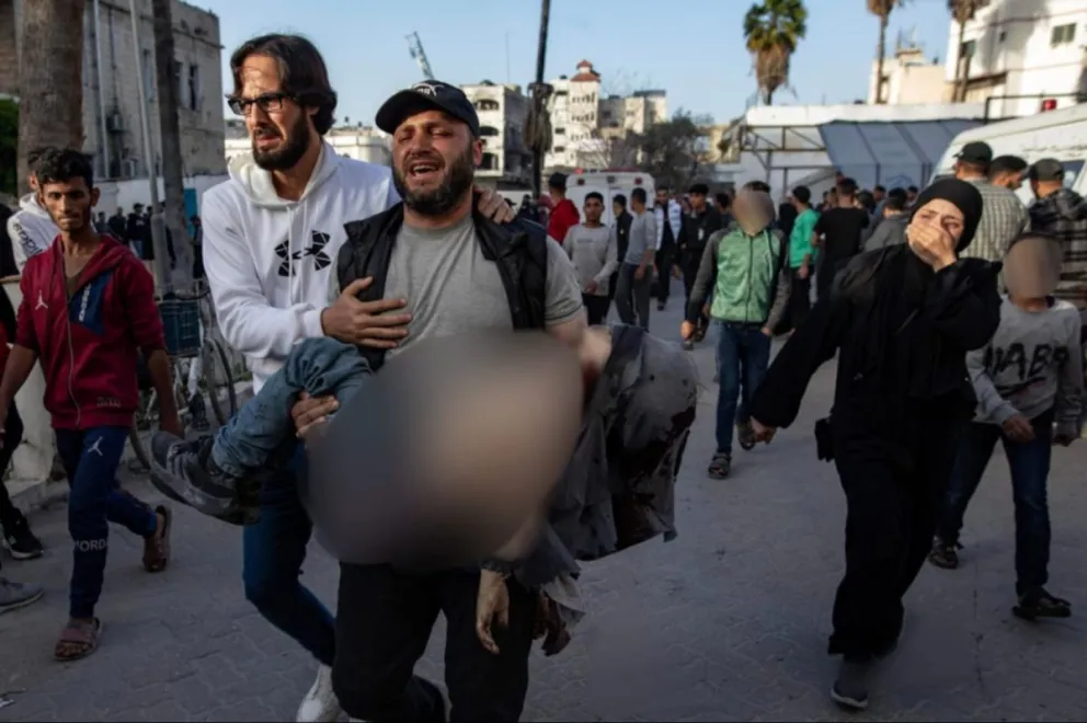 Un hombre lleva el cuerpo de su hijo, muerto en un ataque aéreo israelí, en Gaza el 3 de abril. Foto: EFE