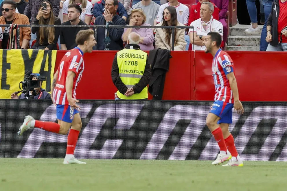 Barrios (izq.) celebra con Koke el gol de la victoria ante el Sevilla. Foto: EFE.