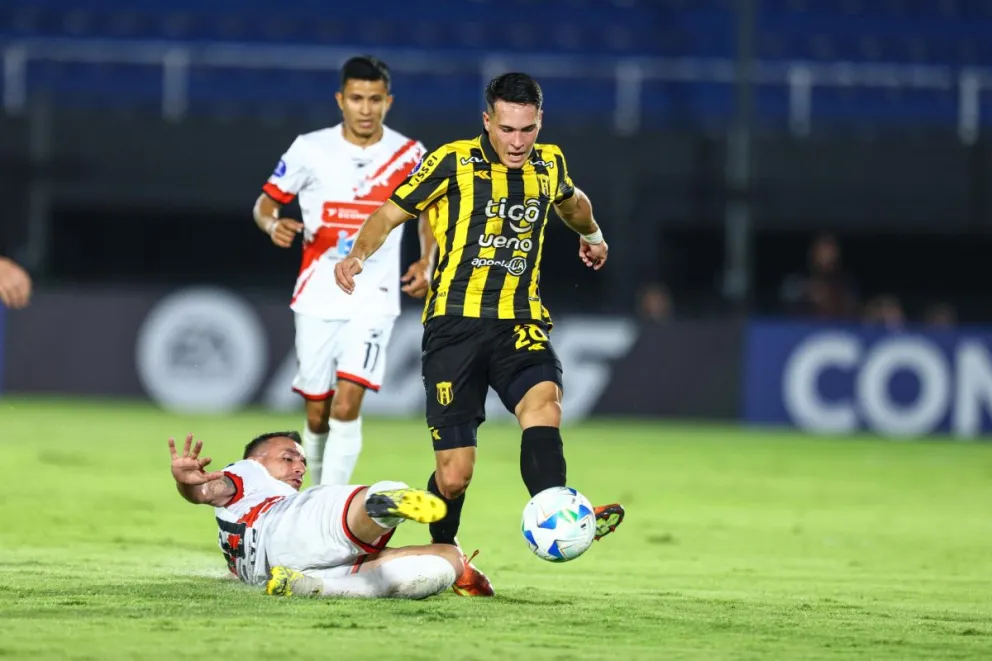 Martín Prost, en el piso, trata de sacarle la pelota a Aleandre Maidana, jugador de Guaraní. Foto: Conmebol Sudamericana