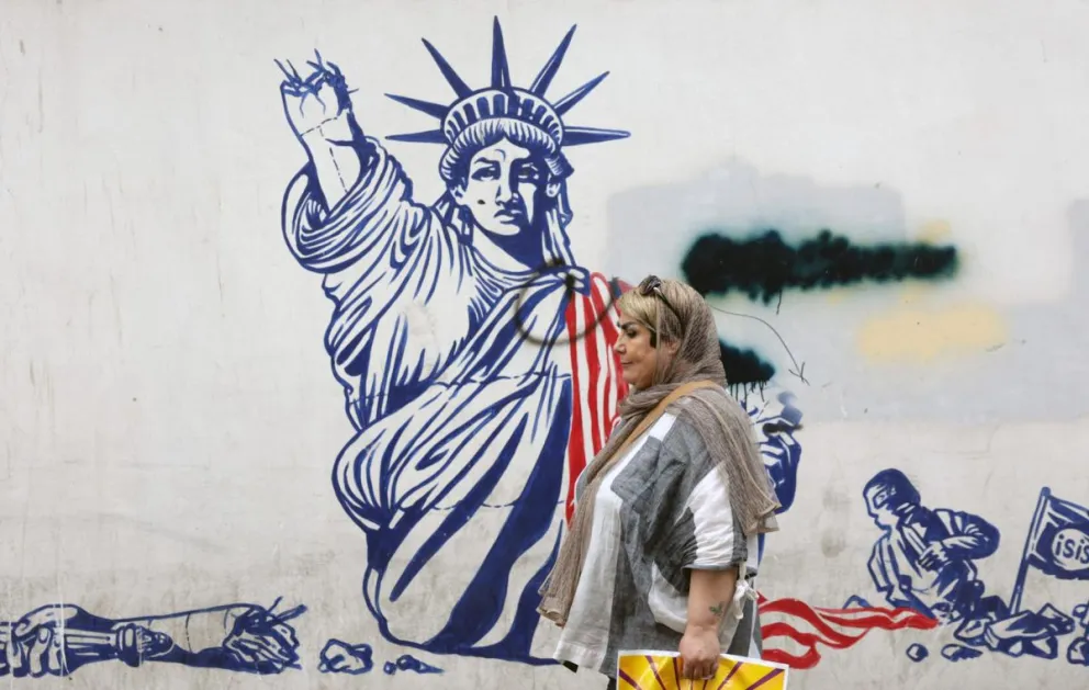 Una mujer pasa cerca de un mural antiestadounidense en Teherán este sábado, el mismo día que representantes de Irán y EE.UU se reúnen indirectamente en Omán. Foto: EFE