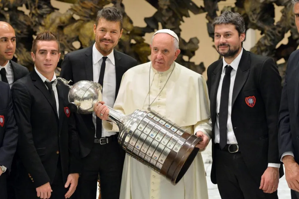 El papa Francisco con el trofeo de la Copa Libertadores, rodeado de miembros de San Lorenzo, en 2014. Foto: EFE.
