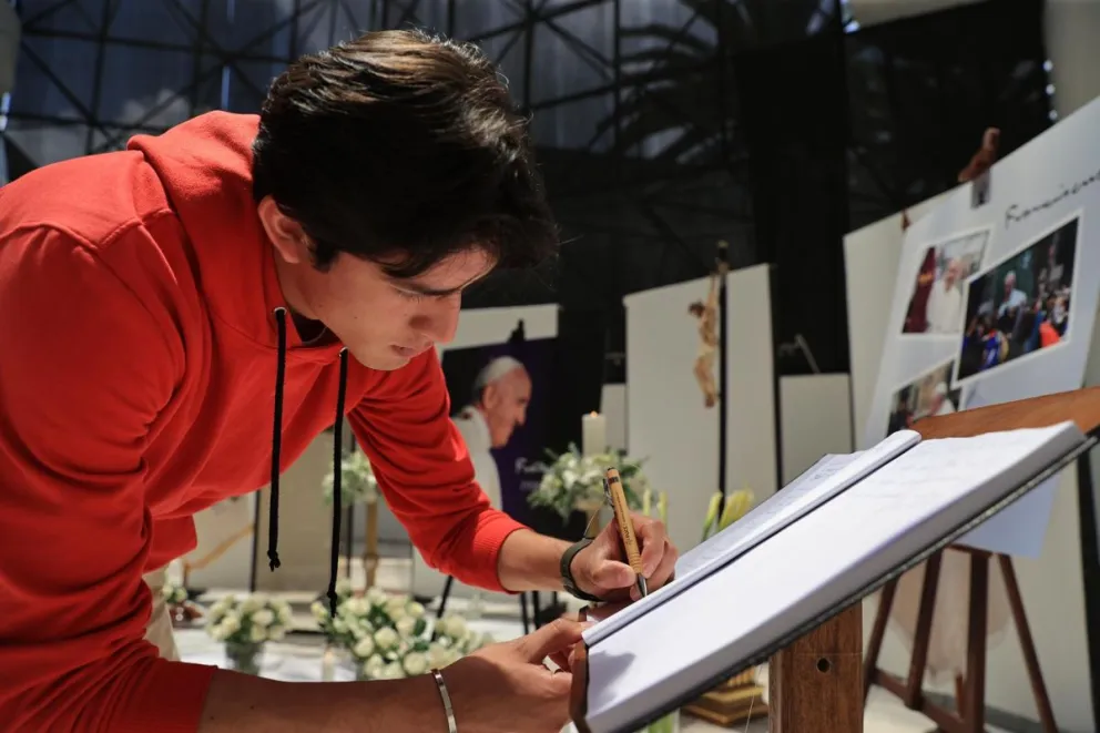 Una persona firma un libro de condolencias recordando al papa Francisco, este 22 de abril de 2025 en Quito (Ecuador). Foto: EFE
