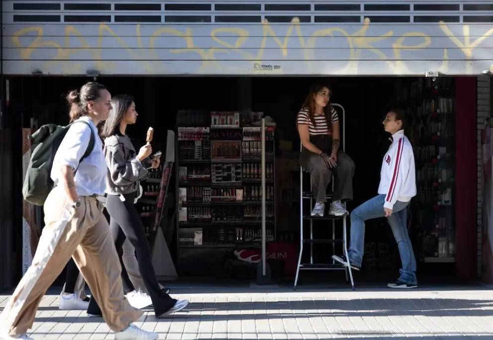 Españoles caminan por una tienda sin luz en Madrid. Foto: El País