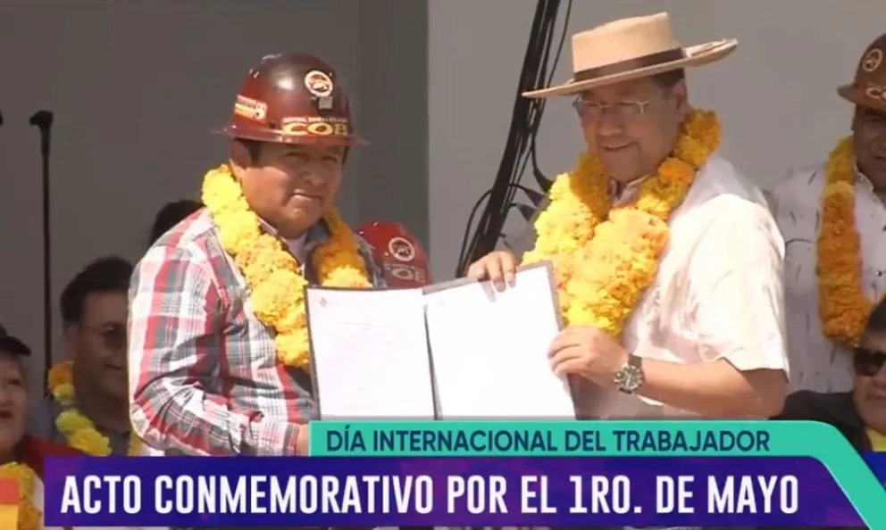El dirigente de la COB, Juan Carlos Huarachi y el presidente Luis Arce, quien entrega los papeles de los vehículos que regaló. Foto: Bolivia TV.