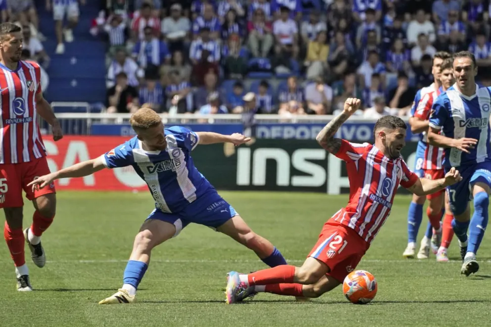 Galán (der.), del Atlético de Madrid, cae al suelo en una acción con Vicente, del Alavés. Foto: EFE.