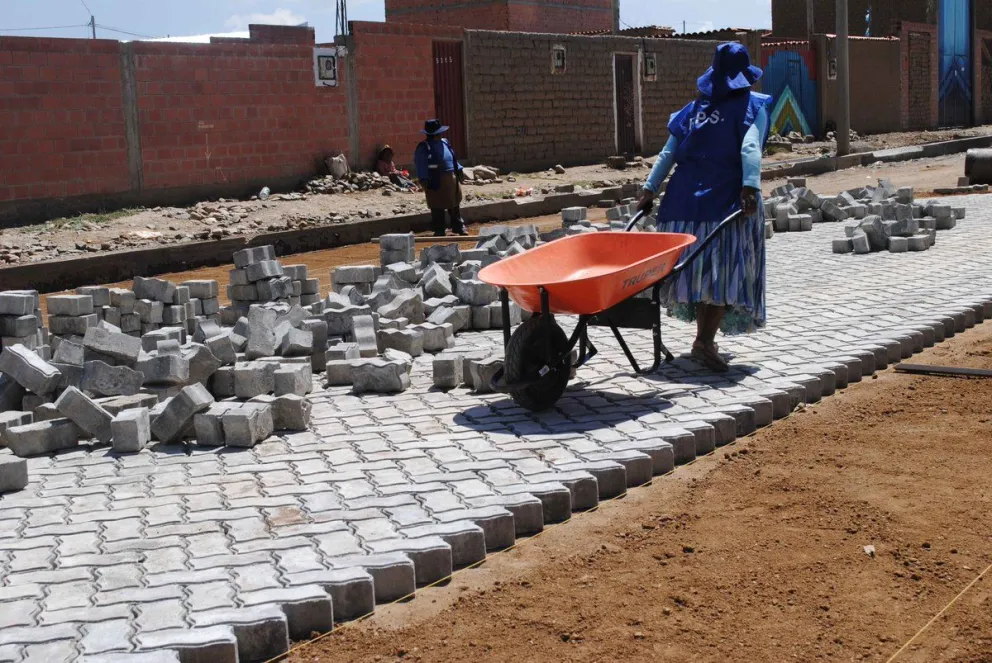 Una trabajadora temporal en tareas de enlosetado de una calle en La Paz. Foto: ABI- FPS