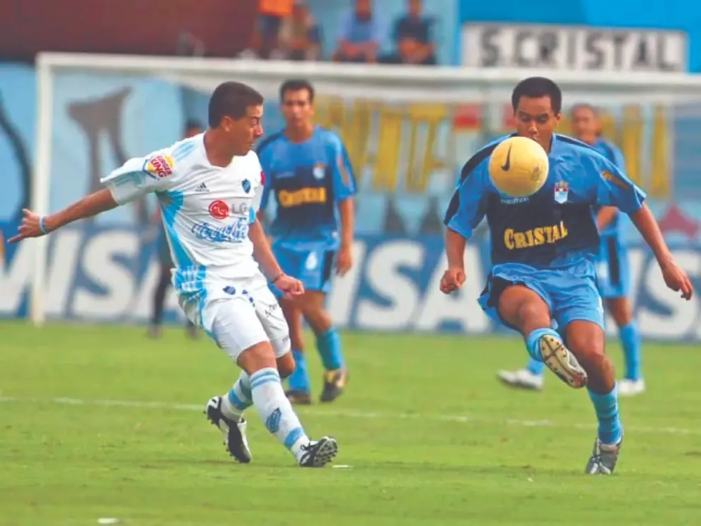 Raúl Justiniano trata de quitar el balón a un jugador de Sporting Cristal en el partido que se disputó en Lima en la versión de 2006. Foto: Andina