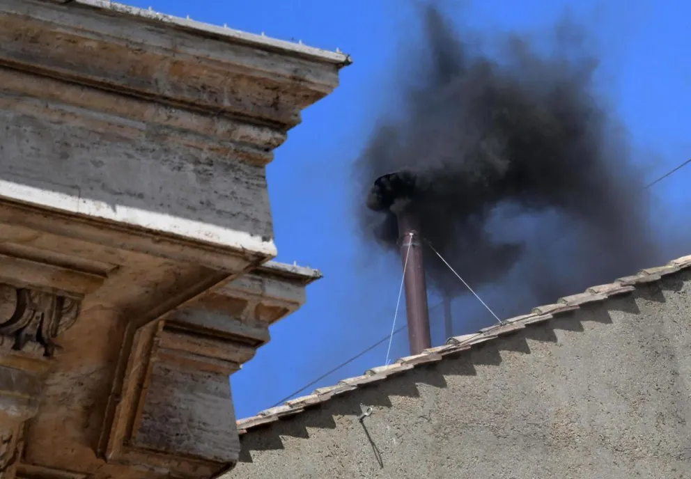 Humo negro sale de la chimenea del tejado de la Capilla Sixtina. Foto: EFE