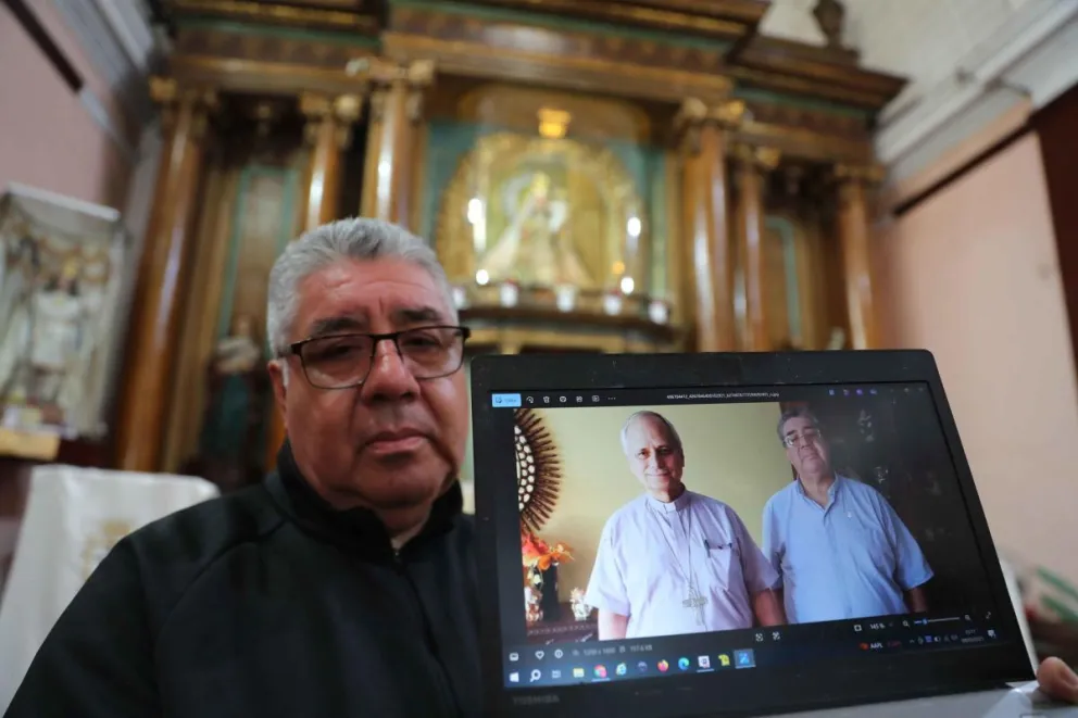 El sacerdote José del Rosario, de la basílica Nuestra Señora del Carmen, muestra una foto con el entonces administrador apostólico de la Diócesis del Callao, Robert Prevost. Foto: EFE