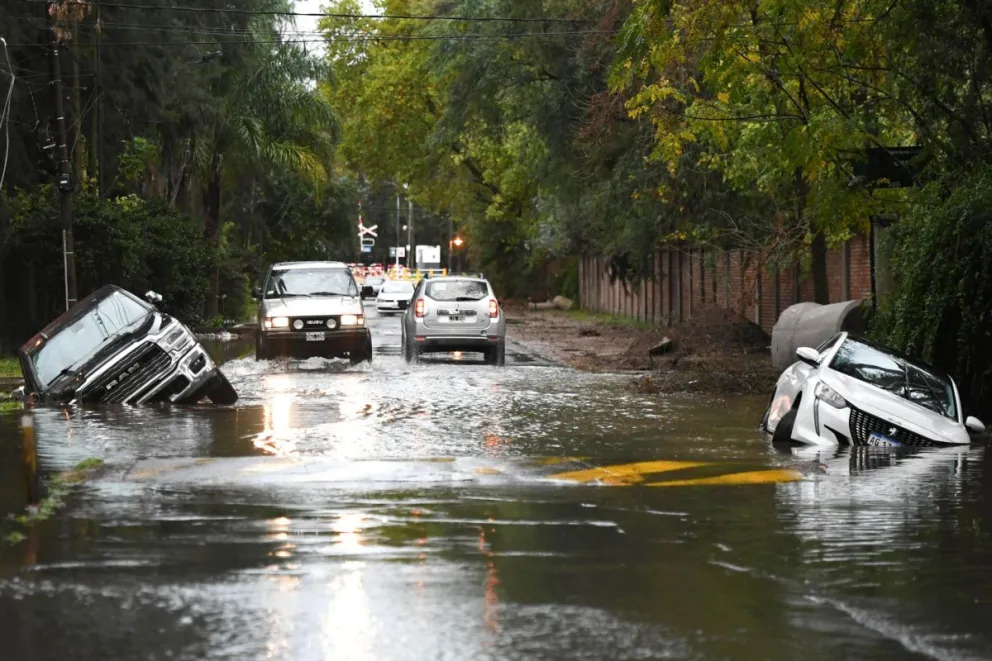 Vehículos atrapados en medio de la vía por una inundación este sábado, en el barrio La Bota. Fotos: EFE