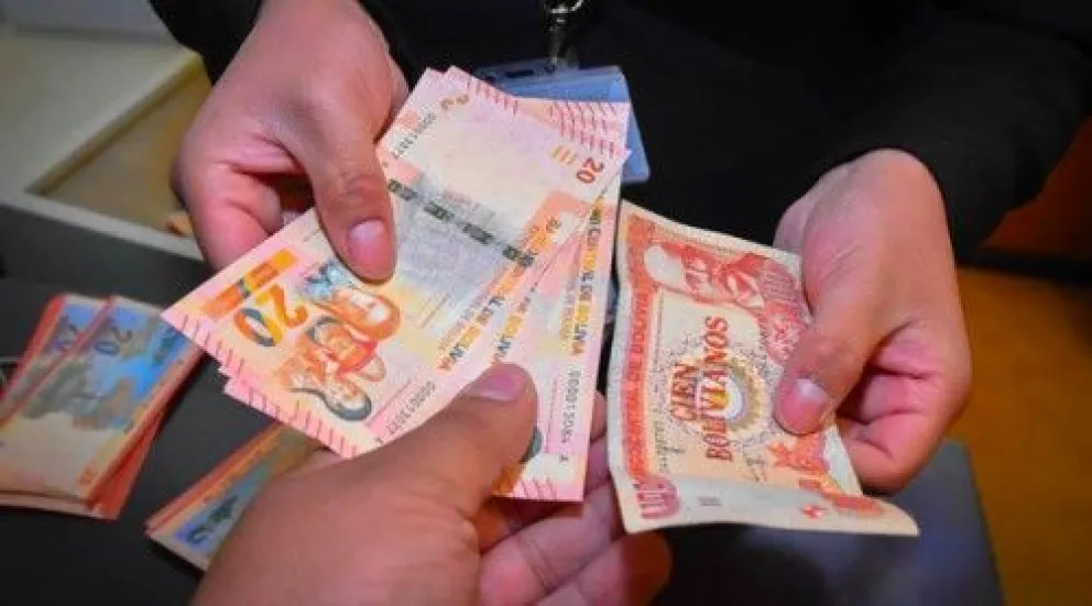 Un ciudadano sostiene bolivianos. Foto: Ministerio de Economía