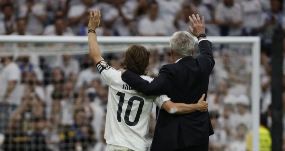 Modric (10) y Ancelotti saludan a la aficion madridista. Foto: EFE