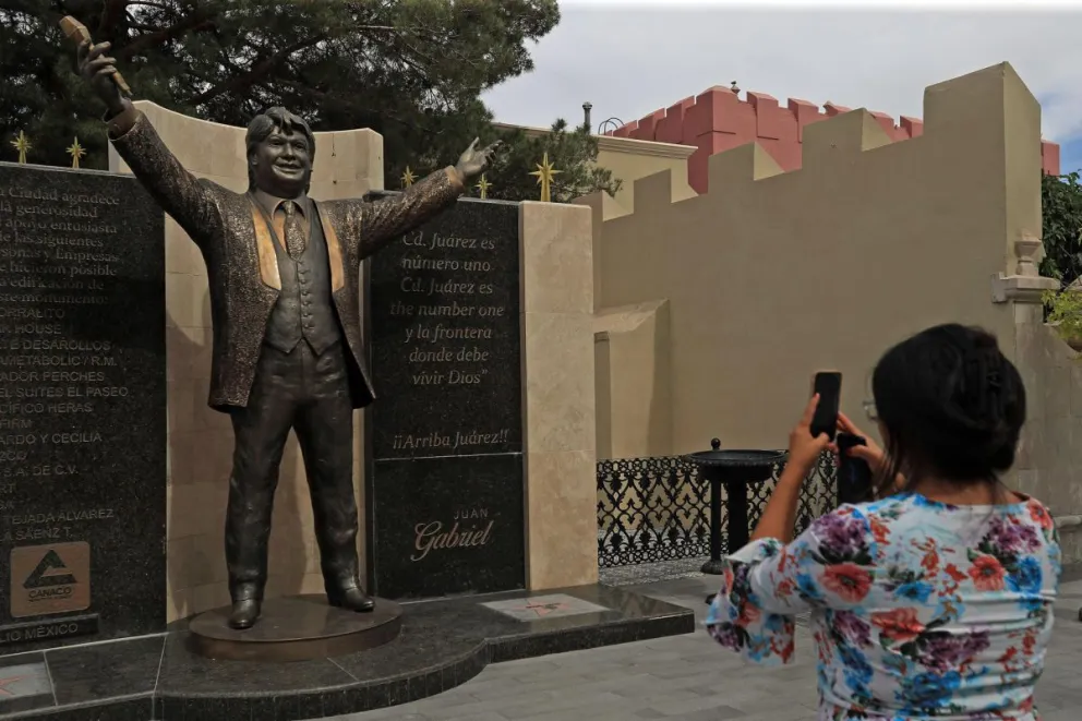 Una mujer toma una fotografía de la estatua del cantautor mexicano Juan Gabriel este 25 de mayo de 2025, en Ciudad Juárez, Chihuahua (México). Foto: EFE