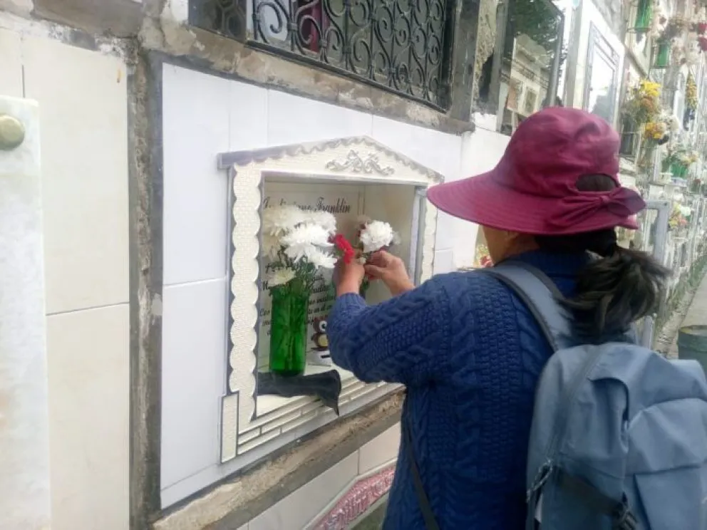 Una persona pone flores en un nicho del Cementerio General.    Foto: AMUN
