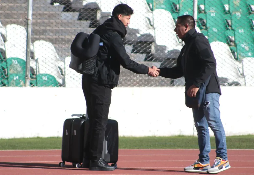 Miguelito Terceros, vestido todo de negro y con su maleta, saluda a un miembro del personal de seguridad a su llegada al Siles. Foto: Agencia Marka Registrada