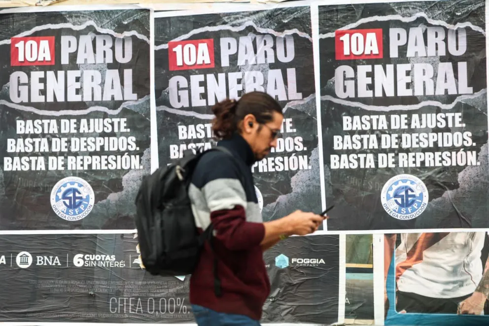 Fotografía de archivo en donde una persona camina frente a carteles que anuncian un paro nacional en la ciudad de Buenos Aires (Argentina). Foto: EFE