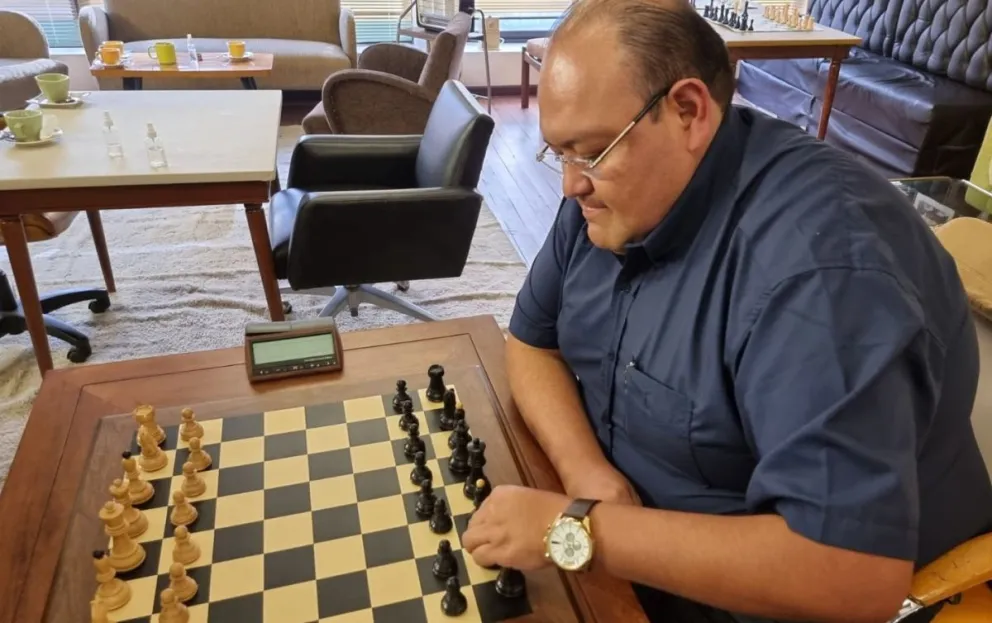 Zambrana junto a un tablero del deporte ciencia. Foto: Federación Boliviana de Ajedrez.