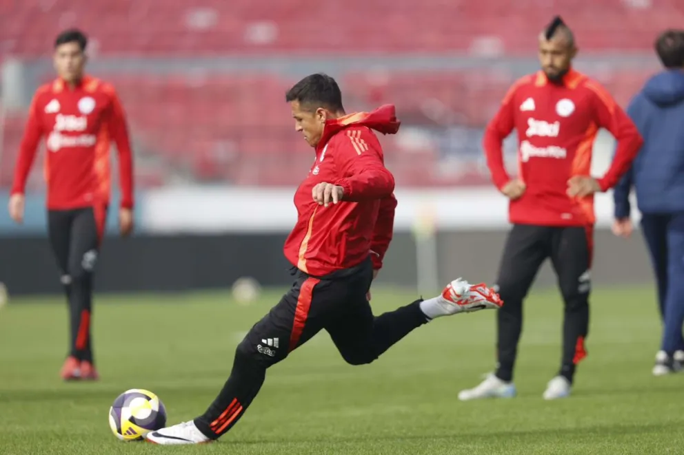 Alexis Sánchez le pega a la pelota en el cierre de entrenamientos de Chile. Metros atrás lo observa Arturo Vidal. Foto: La Roja