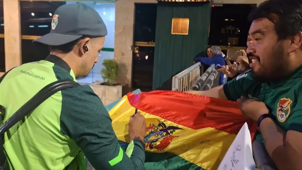 El arquero Guillermo Viscarra firma en una bandera de Bolivia. Foto: Jorge Asturizaga. 