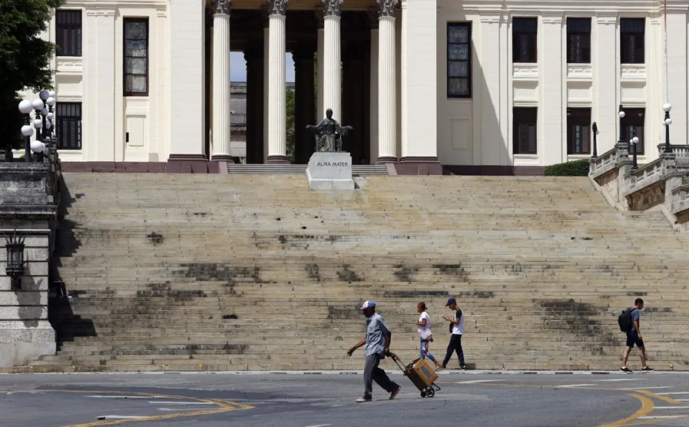 Personas caminan frente a la entrada de la Universidad de La Habana este sábado, en La Habana (Cuba). Foto: EFE