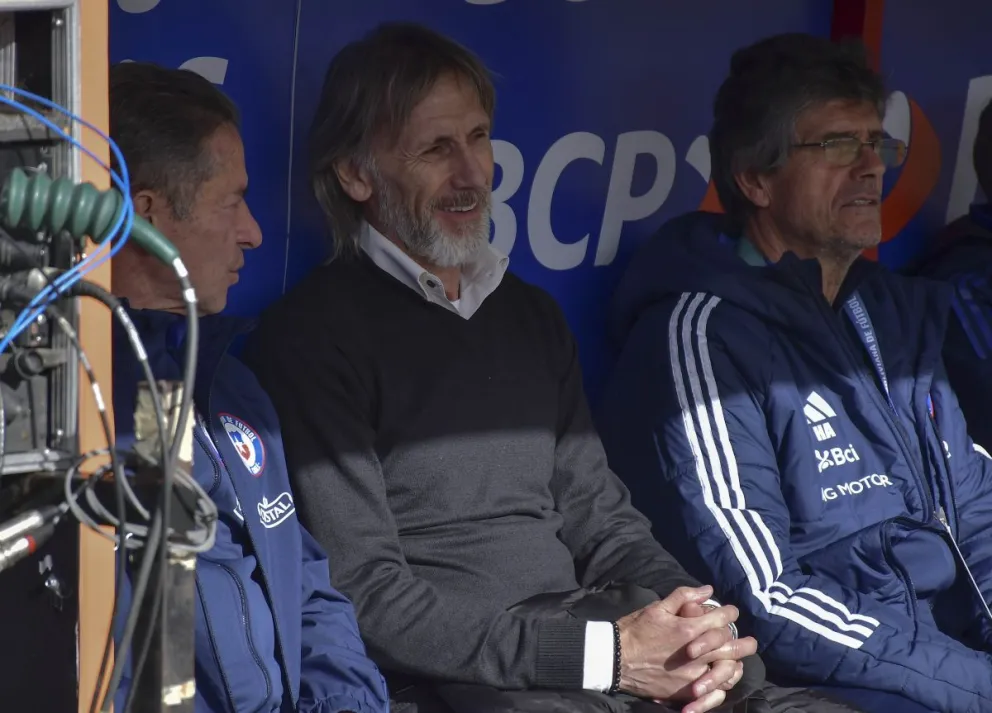 Ricardo Gareca (centro) observa el partido desde la casamata de los suplentes de Chile. Foto: APG