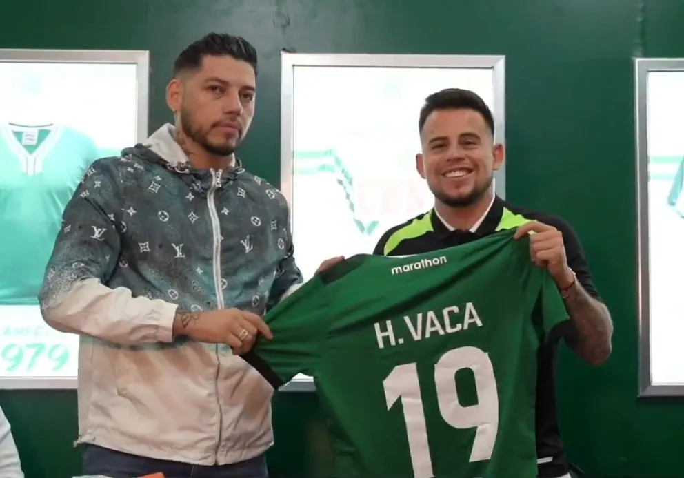 Gustavo Gutiérrez y Henry Vaca sostienen la camiseta número 19 de Oriente. Foto: captura de video