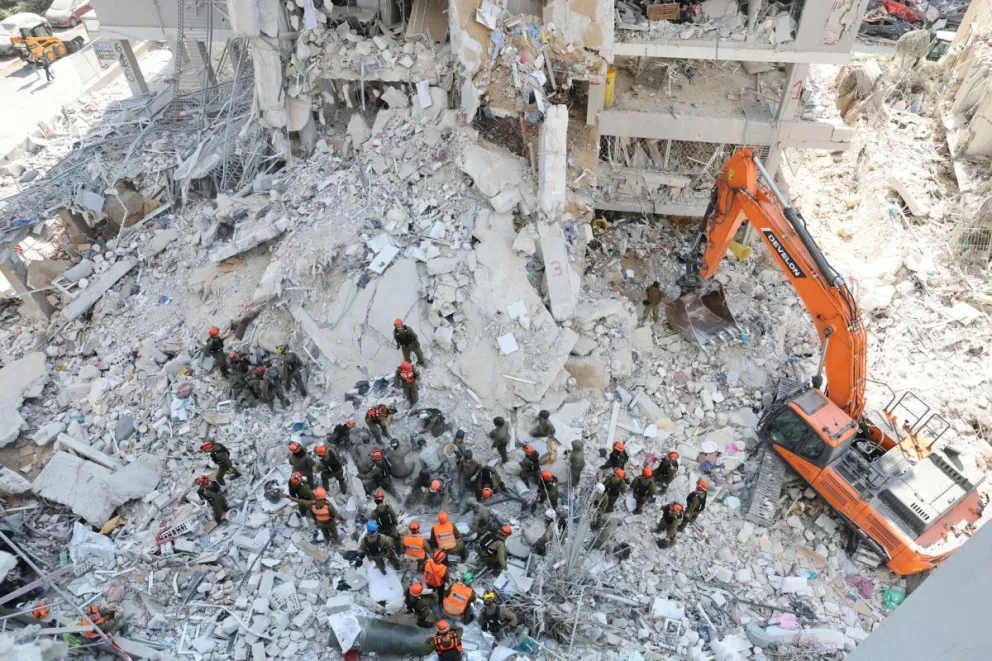 Equipos de rescate este domingo en el lugar del impacto de un misil en el centro de Israel tras un ataque de Irán. Foto: EFE