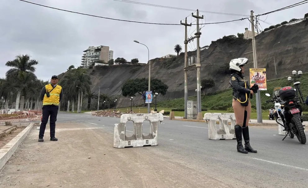 Integrantes de equipos de seguridad cierran la avenida Costa Verde por derrumbes en el acantilado, producto del sismo ocurrido este domingo, en Lima (Perú). Foto: EFE