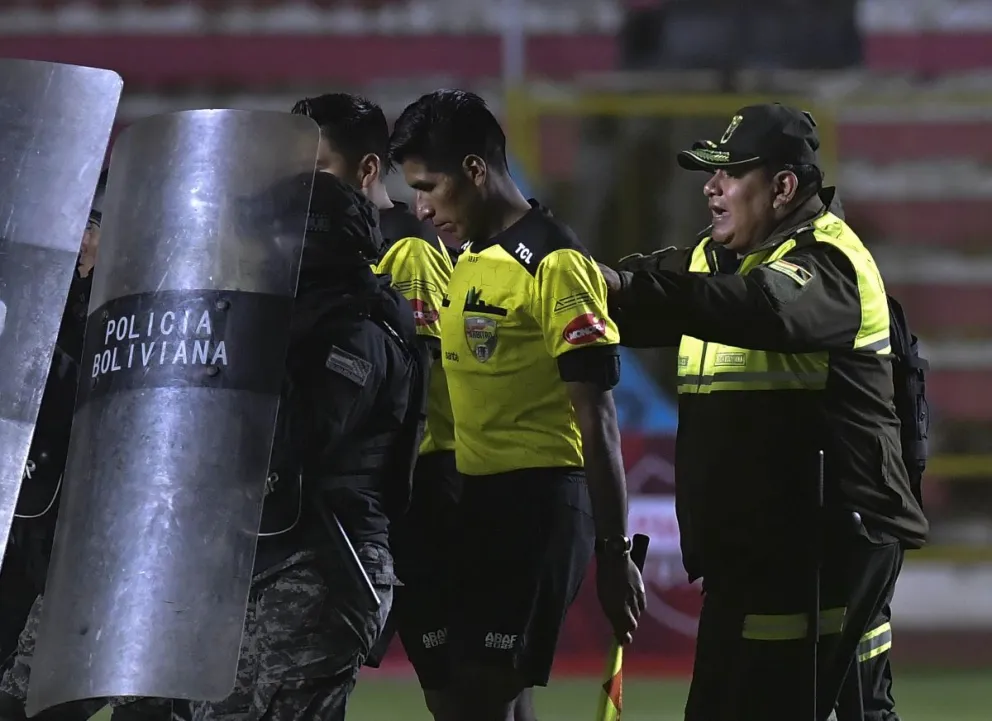 Gabriel Mendoza se retira del campo de juego del Siles con la custodia policial. Foto: APG
